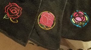 Three black towels with three different Utena inspired rose patterns.